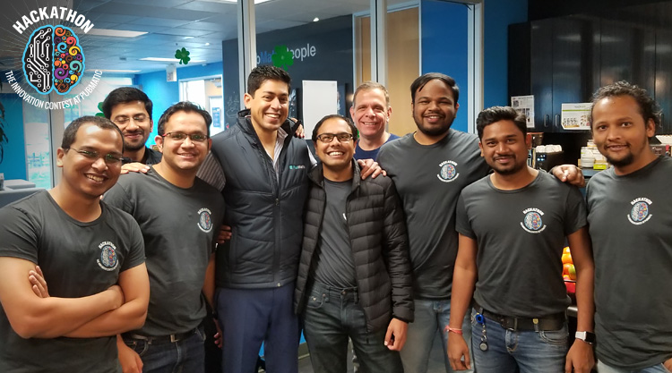 A crowd of PubMatic employees smiling together and wearing matching grey shirts