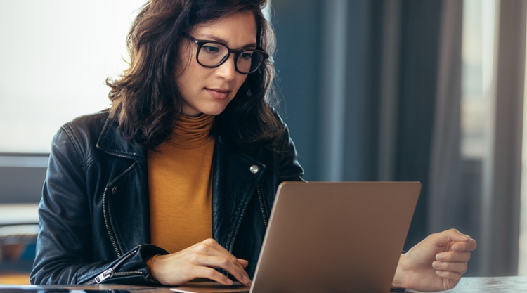 A woman looking at her laptop in an office space