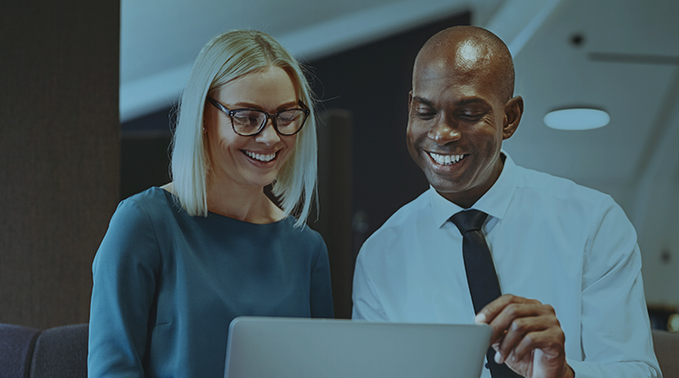 Smiling adult woman and smiling man looking at laptop screen