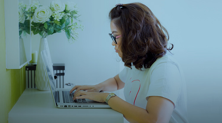 Young woman typing on computer while looking at the screen