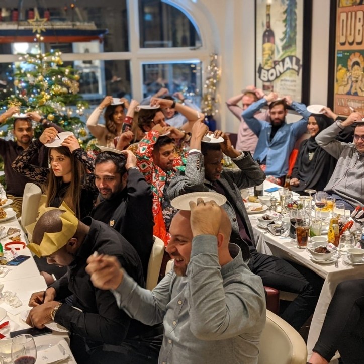 A group of people sitting at a restaurant with plates over their head