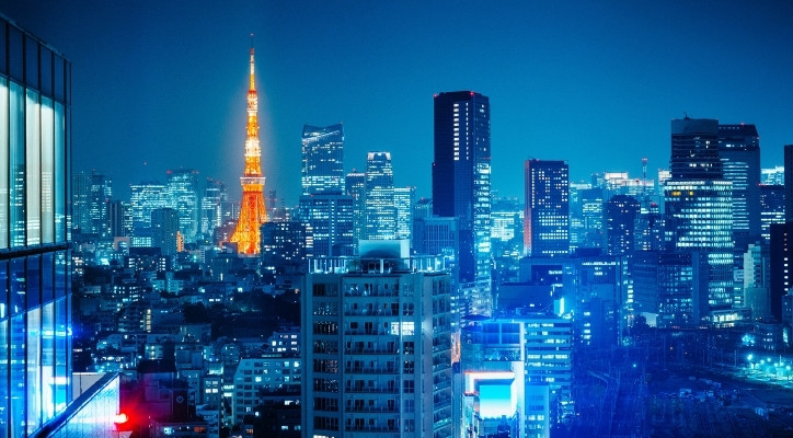 An image of Tokyo, Japan at night. All of the lights in the city are blue except for a tower in the distant that's yellow