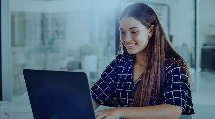 Young woman typing on her laptop in an office