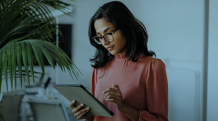 Adult woman holding a tablet while working in an office space