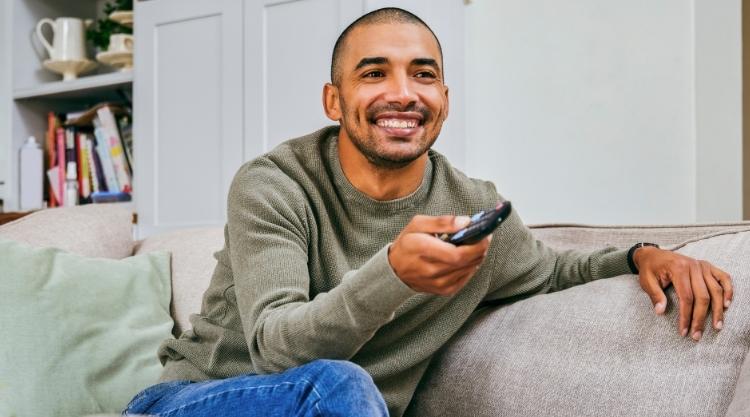 Shot of a young man relaxing at home watching TV