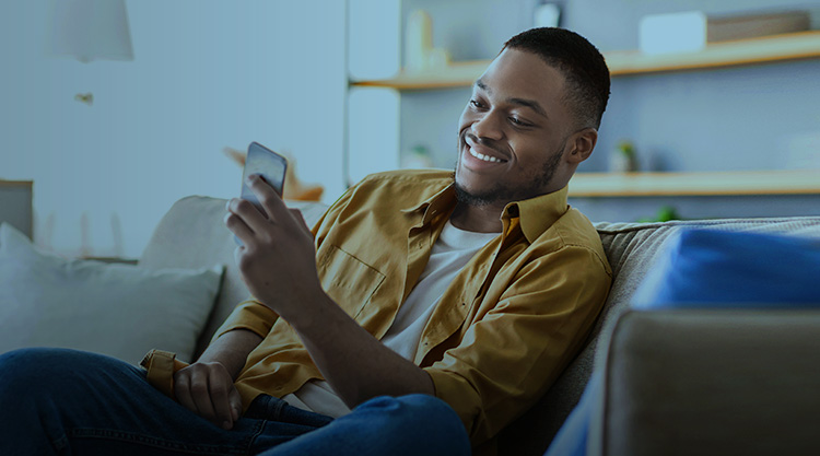 Side view of adult man using smartphone at home