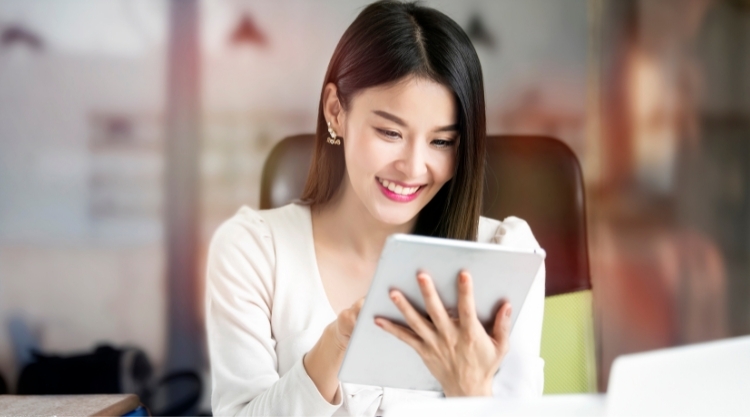 a smiling woman uses her mobile device