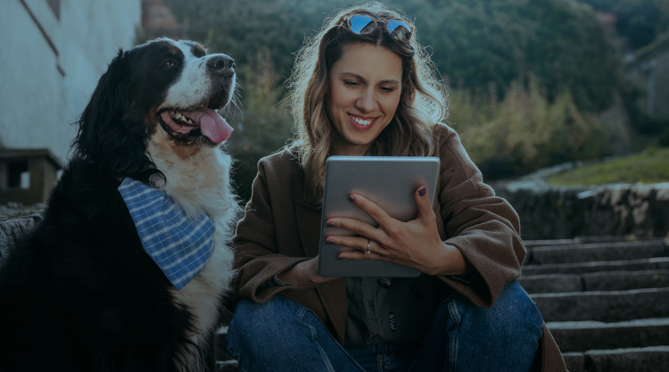 Woman using tablet and cute dog waiting for her to finish typing