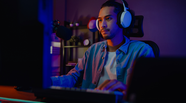 Man playing games at night with headphones