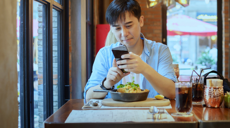 Man holding phone at dinner