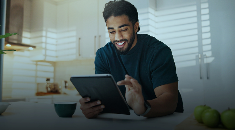 Young man smiles as he navigates his tablet device